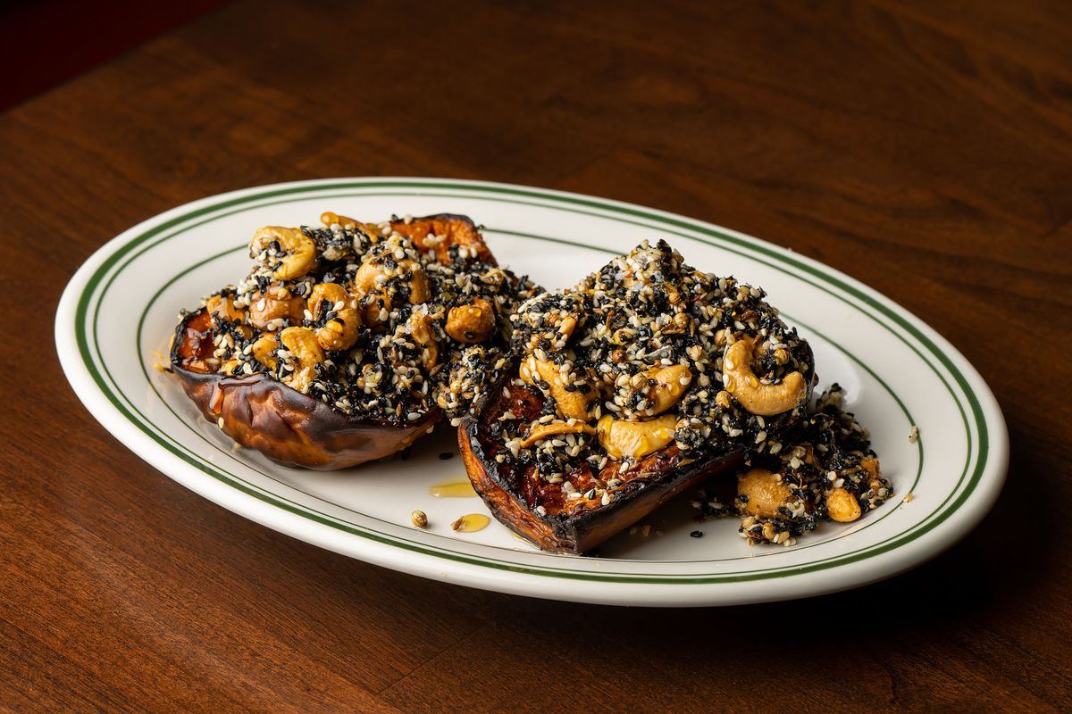 A split butternut squash with roasted seeds and cashews.