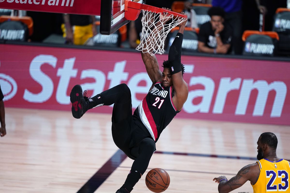 Hassan Whiteside of the Portland Trail Blazers slam dunks over LeBron James of the Los Angeles Lakers during the second half in Game 1 of Round 1 of the NBA Playoffs at AdventHealth Arena at ESPN Wide World Of Sports Complex on August 18, 2020 in Lake Buena Vista, Florida.