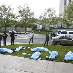 Protesters demonstrate outside the Salt Lake County District Attorney’s Office in Salt Lake City on Friday, May 24, 2019. The protesters laid on the grass in tarps with toe tags of individuals killed by police.