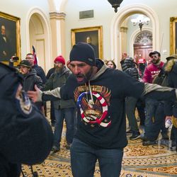 Supporters of President Donald Trump gesture to U.S. Capitol Police in the hallway outside of the Senate chamber at the Capitol in Washington on Wednesday, Jan. 6, 2021.
