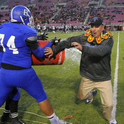 Bingham Head Coach Dave Peck dodges the water bucket as the Bingham Miners defeated the Brighton Bengals during the 5A State Championships at Rice Eccles Stadium on Friday, November 22, 2013.