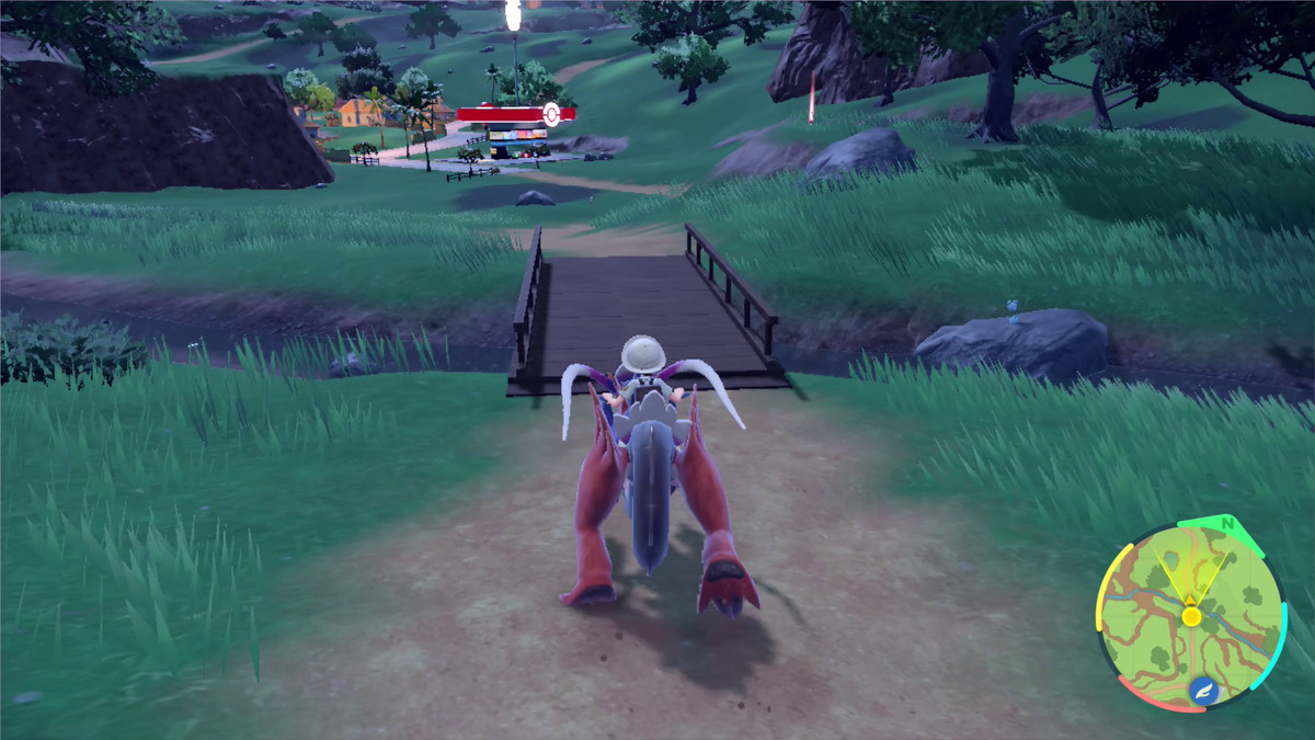 A Pokémon trainer rides Koraidon on a dirt road in a field in the Paldea region of Pokémon Scarlet.