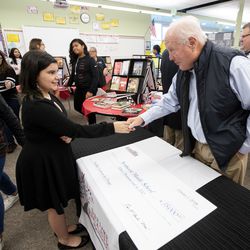 Coach Ron McBride shakes hands with Rebekah Maestas as his foundation gives $15,000 to Northwest Middle School to support the Healthy Learners Initiative. on Monday, Oct. 8, 2018.