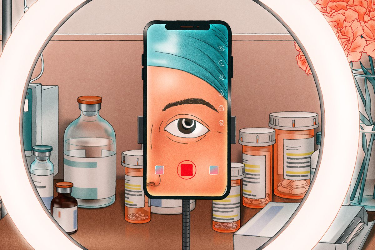 An illustration from the perspective of a person making a TikTok video. Their reflection, a close up of their eye, is seen on the screen of the smart phone recording the video in the center of the frame. Behind the phone is a ring light. Seen in the background of the image is a desk covered in medical supplies, including several pill bottles and an IV. There is also a vase of orange flowers. 