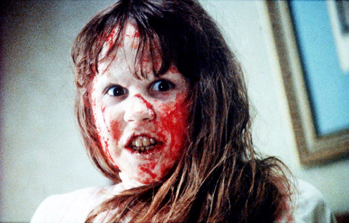 Regan (Linda Blair), a tousle-haired young girl snarling and covered with blood, in The Exorcist