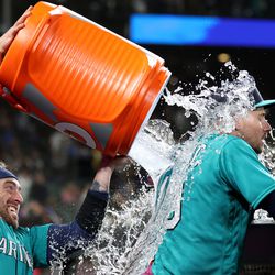 Tom Murphy #2 douses Jarred Kelenic #10 of the Seattle Mariners with water after the game against the Colorado Rockies at T-Mobile Park on April 14, 2023 in Seattle, Washington.