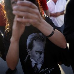 A protester wearing a T-shirt  decorated with the image of former Turkish leader Mustafa Kemal Ataturk, claps hands  during a protest   at Taksim Square in Istanbul, Monday, June 3, 2013. Demonstrations that grew out of anger over excessive police force have spiraled into Turkey's biggest anti-government demonstrations in years, challenging Prime Minister Recep Tayyip Erdogan's power.