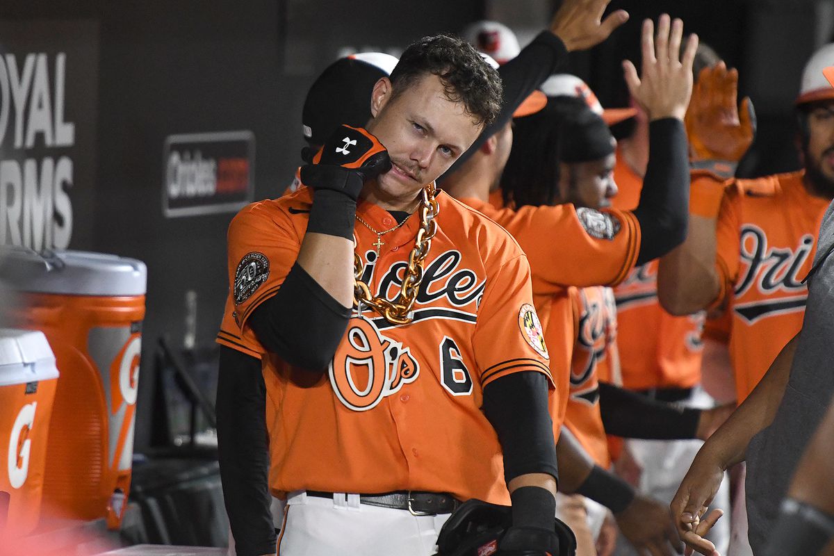 Ryan Mountcastle, wearing the Orioles Home Run Chain, makes a silly gesture in the dugout