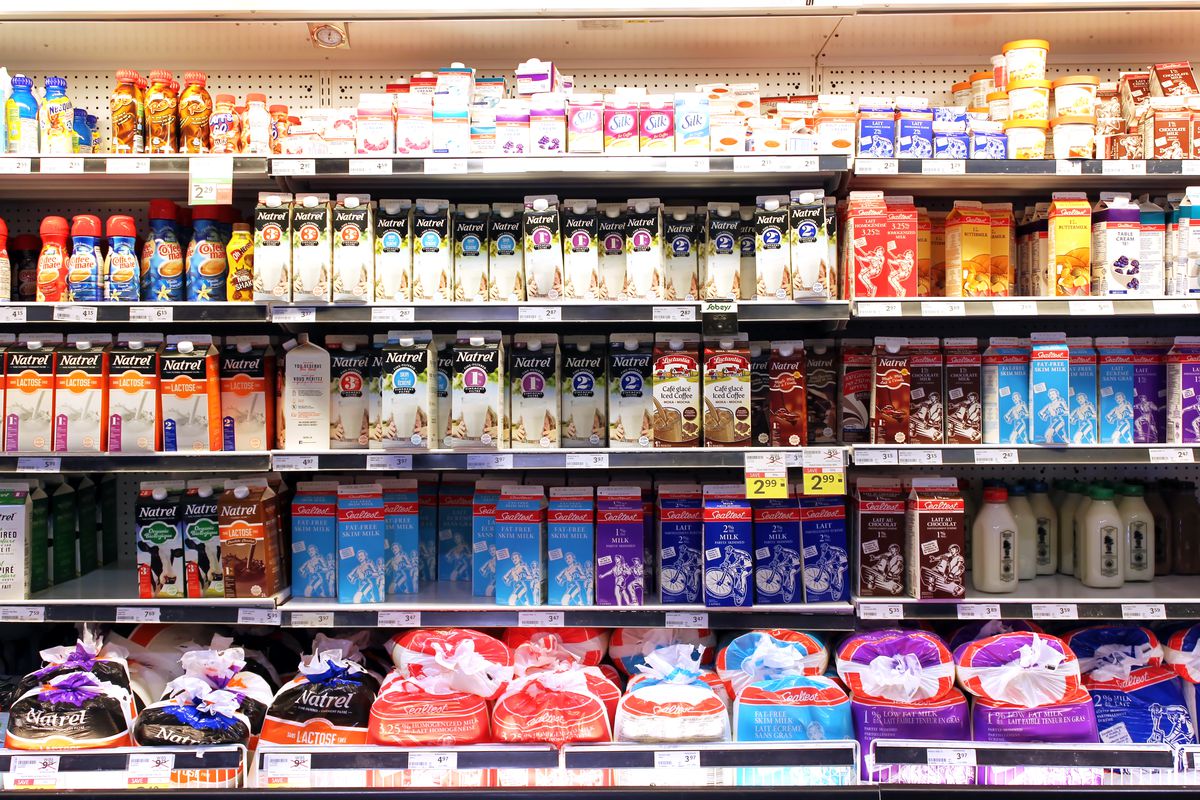 Selection of milk and dairy products on shelves in a supermarket.
