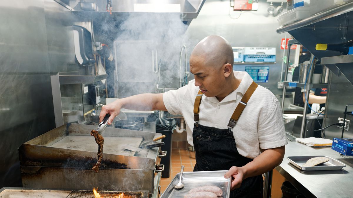 A man in a kitchen about to grill kalbi.