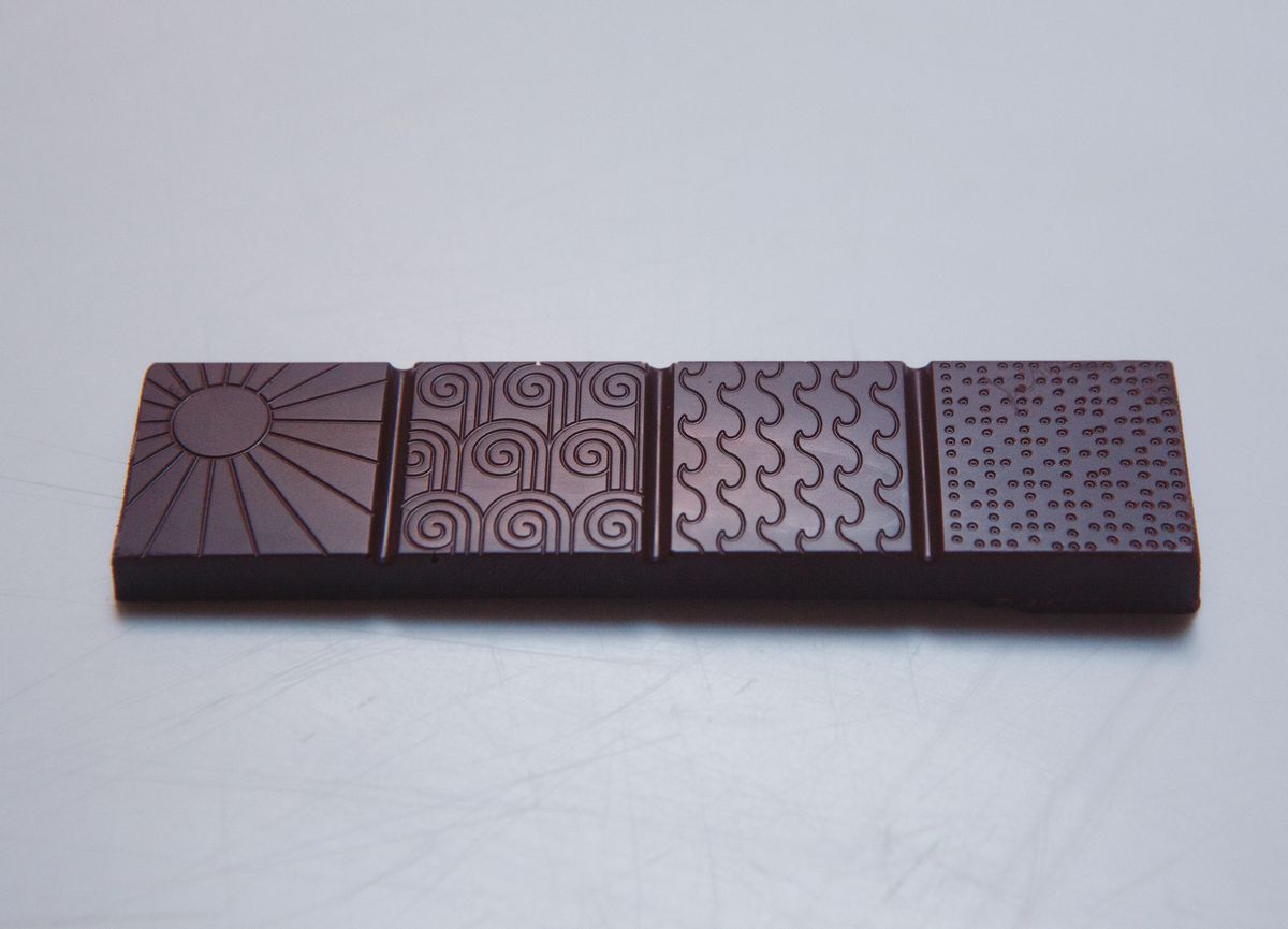A chocolate bar with images engraved on each square.