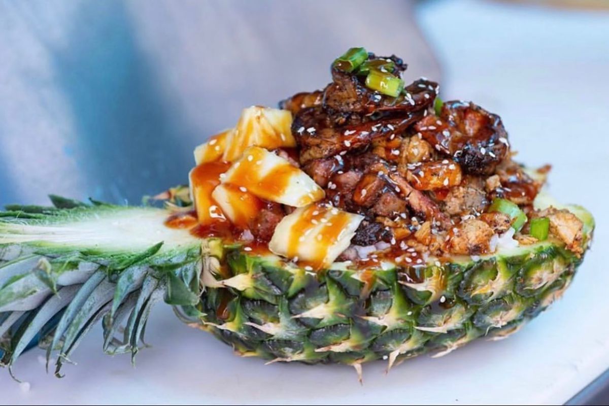 Trap Kitchen’s pineapple bowl stuffed with shrimp and chicken, topped with a glaze.