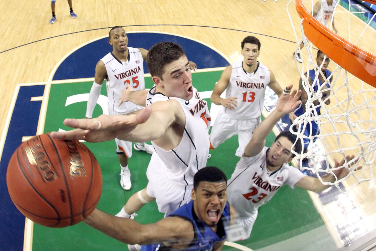 GREENSBORO, NC - MARCH 16: Joe Harris #12 of the Virginia Cavaliers blocks a shot taken by Quinn Cook #2 of the Duke Blue Devils during the finals of the 2014 Men's ACC Basketball Tournament at Greensboro Coliseum on March 16, 2014 in Greensboro, Nor