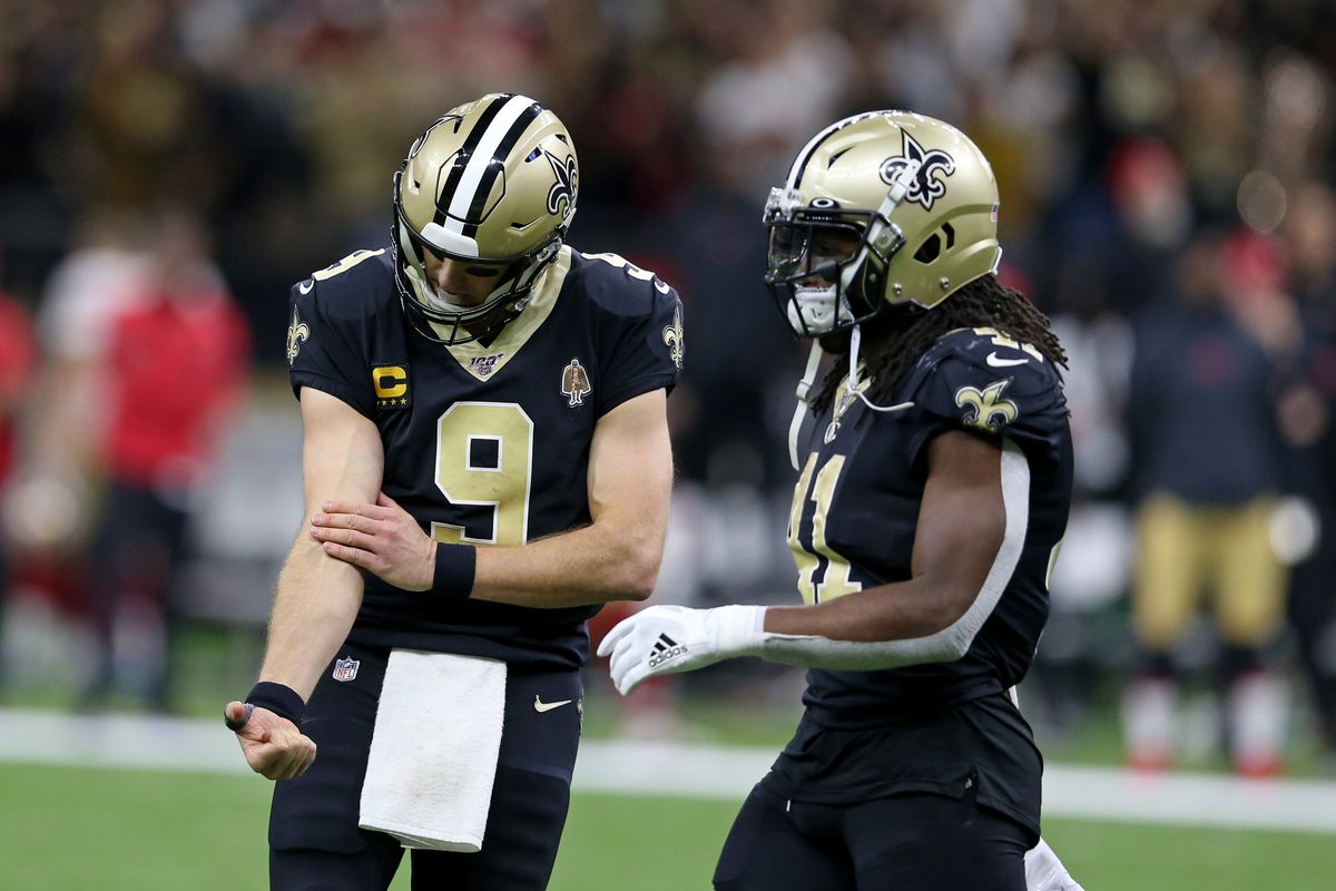 New Orleans Saints quarterback Drew Brees looks at his right arm after being hit in the second half of their game against the San Francisco 49ers at the Mercedes-Benz Superdome. Saints running back Alvin Kamara is at right.&nbsp;