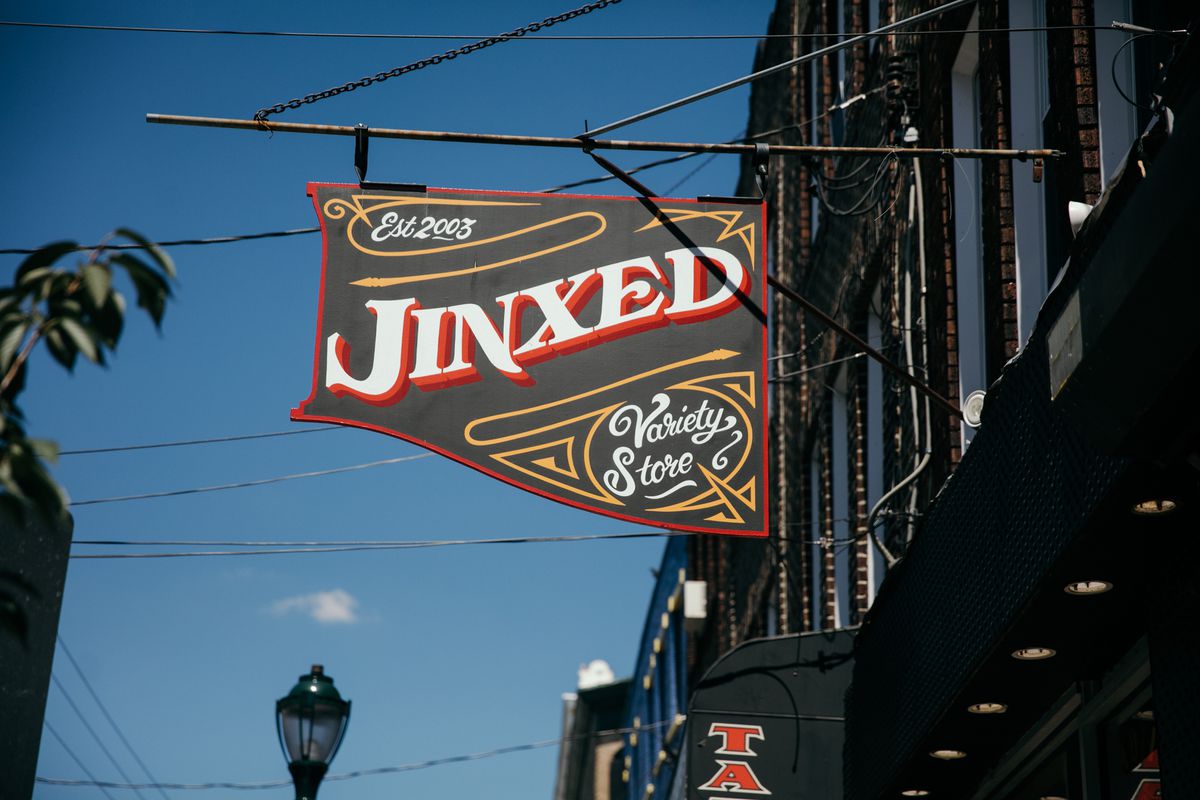 An oldtimey sign for Jinxed, an antique shop. 