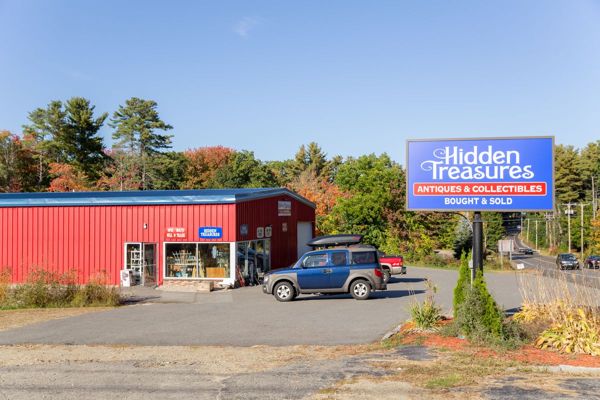 A bright red antique warehouse in Maine on the side of the road.