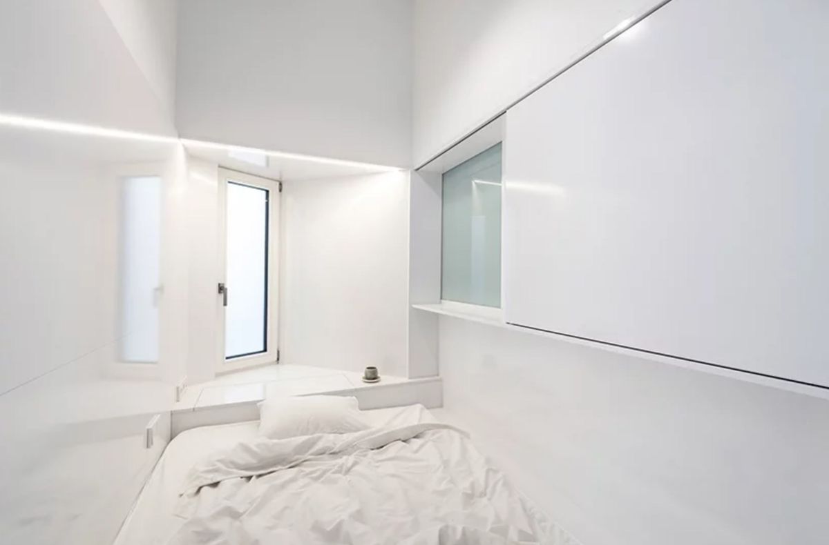 Bedroom nook with white walls and white bed
