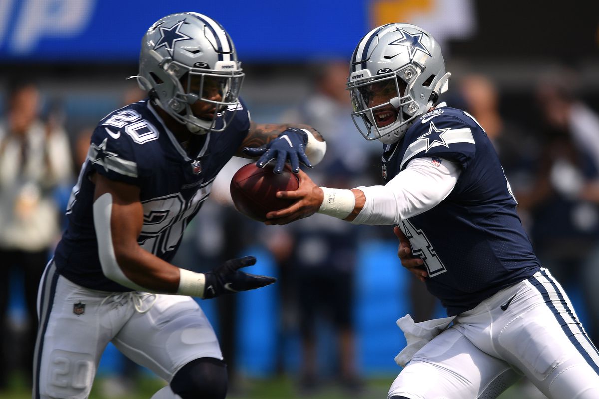 Dallas Cowboys quarterback Dak Prescott (4) hands the ball off to running back Tony Pollard (20) during warmups before the game against the Los Angeles Chargers at SoFi Stadium.