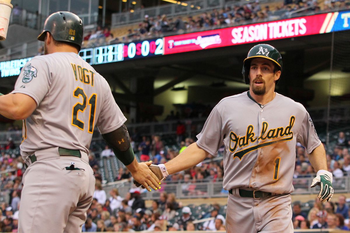Stephen Vogt and Billy Burns celebrate Burns's first-inning run against the Minnesota Twins on Tuesday night.