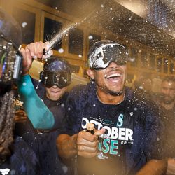 Seattle Mariners center fielder Julio Rodriguez (right) celebrates with teammates in the clubhouse with teammates following a 2-1 victory against the Oakland Athletics to clinch a wild card appearance