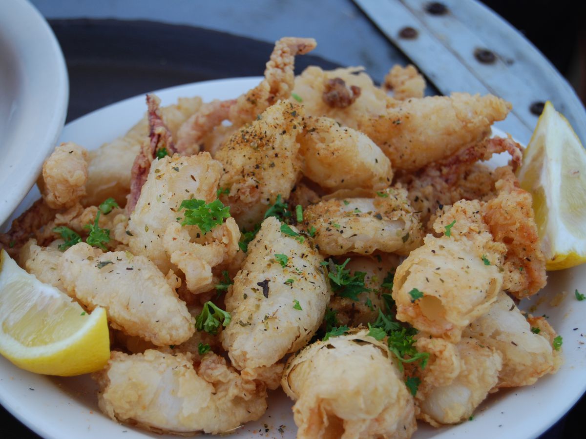 A platter of fresh, fried calamari with lemon slices