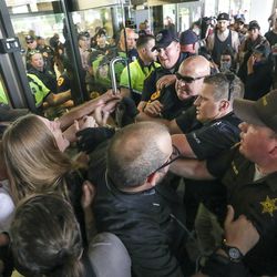 Salt Lake police and Utah Highway Patrol troopers force protesters out of the Chamber of Commerce Building at 175 E. 400 South in Salt Lake City on Tuesday, July 9, 2019. The protest over the Utah Inland Port began at the City-County Building and moved to the Chamber of Commerce Building where the port authority meets.