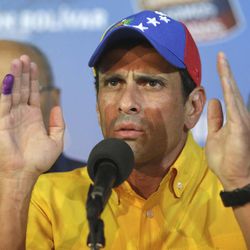 Opposition presidential candidate Henrique Capriles talks to journalist after official results of the presidential elections were announced in Caracas, Venezuela, early Monday April 15, 2013. Capriles is refusing to accept the results of Sunday's presidential election and is demanding a recount.  The official returns announced by the government-dominated electoral council gave the late President Hugo Chavez's chosen successor, Nicolas Maduro, a narrow victory - 50.7 percent to 49.1 percent.(AP Photo/Fernando LLano)