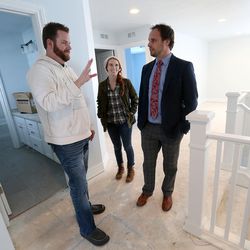 Ryan and Gentry Holbrook walk through the house they are having built with their real estate agent, Brandon Blackwell, in North Salt Lake on Tuesday, Dec. 29, 2015. 