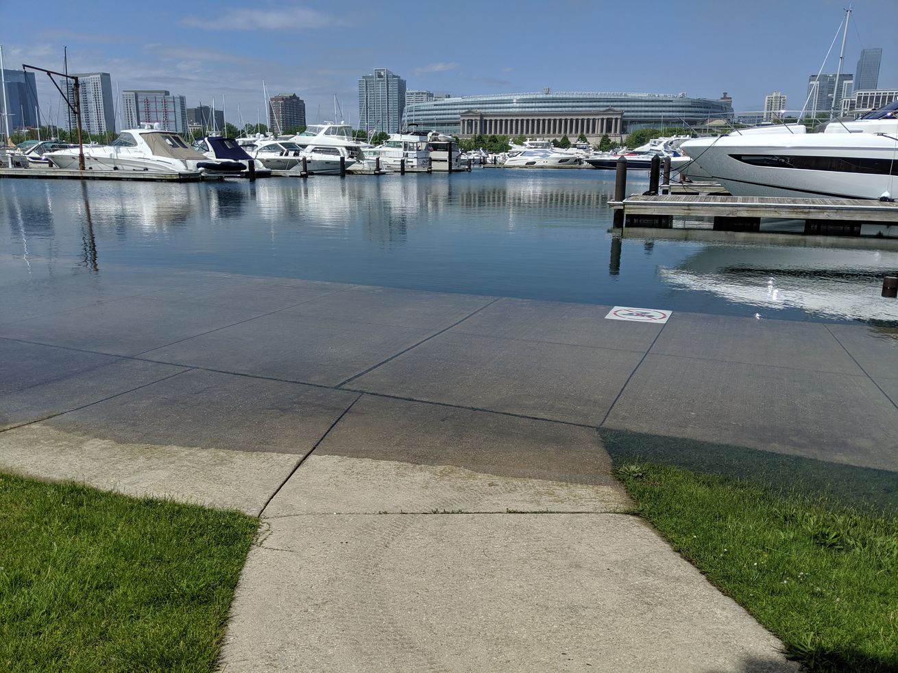 During level swings at Burnham Harbor, the high levels on Lake Michigan flood the sidewalk on Northerly Island across from Soldier Field.