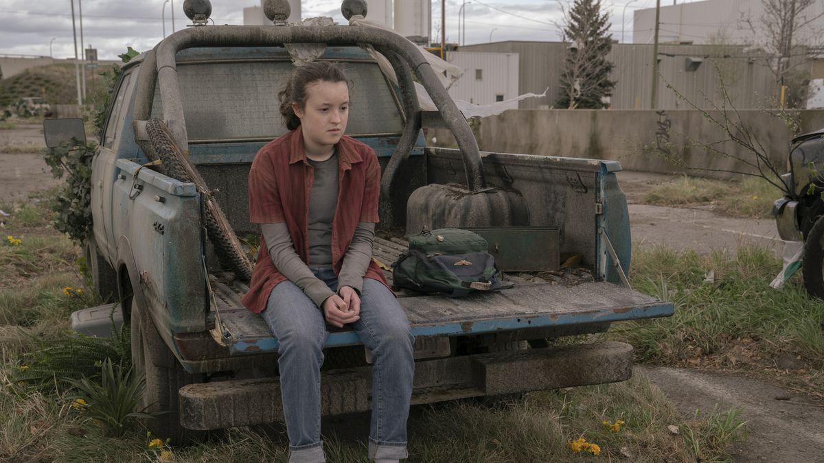 Ellie (Bella Ramsey) sitting on the back of an abandoned pick-up truck looking sad