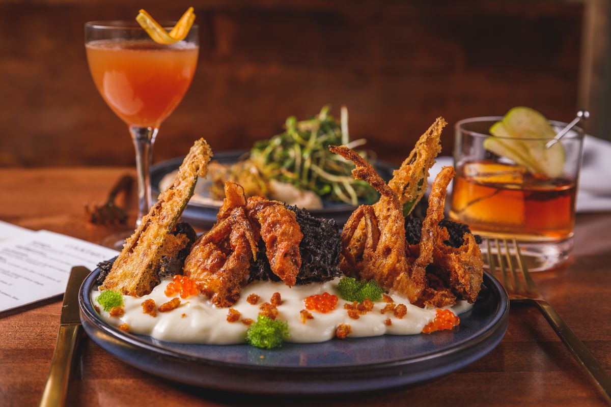 A plate of fried corn is flanked by two cocktails.