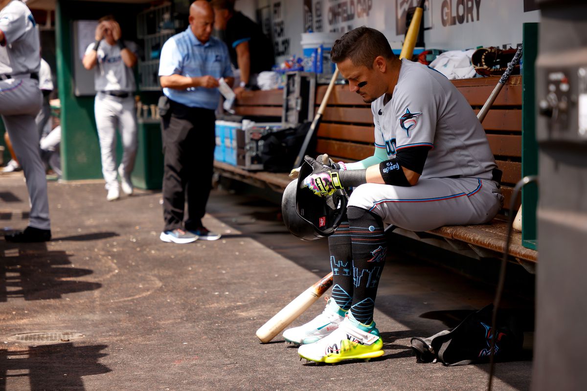 Miguel Rojas #11 of the Miami Marlins sits in the dugout during the game against the Cincinnati Reds at Great American Ball Park on July 28, 2022 in Cincinnati, Ohio.