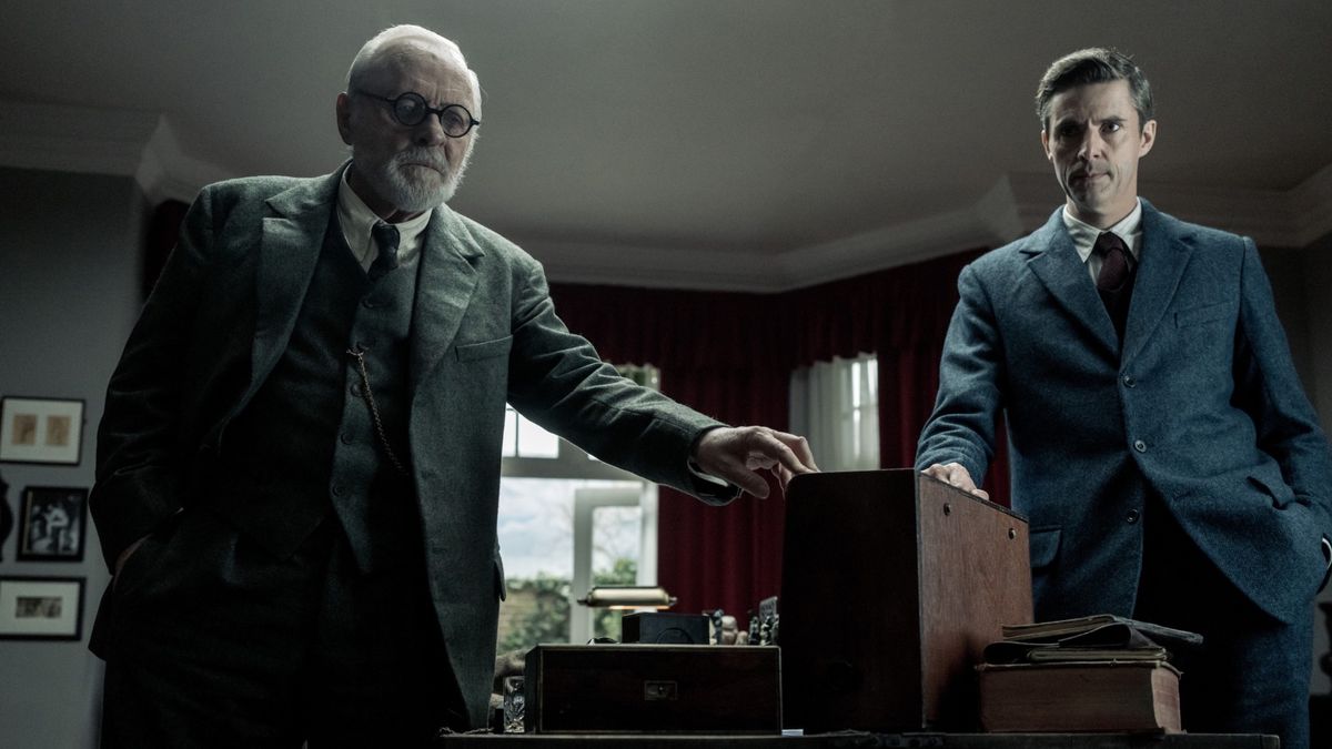 Freud (Anthony Hopkins) and CS Lewis (Matthew Goode) both touch a box in the middle of an old room in Freud’s Last Session