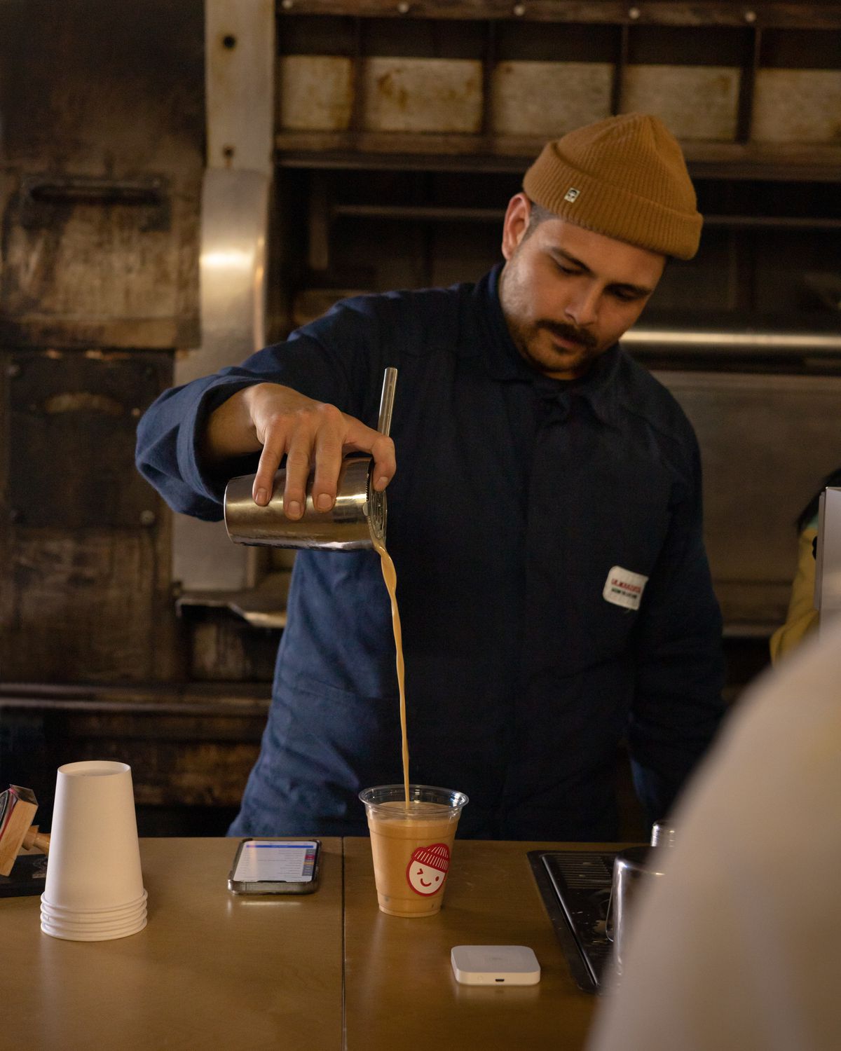 A man pours coffee into a cup.