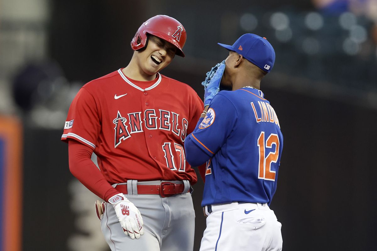 Shohei Ohtani of the Los Angeles Angels has a laugh with Francisco Lindor of the New York Mets at second base after his first inning double at Citi Field on August 26, 2023 in New York City.