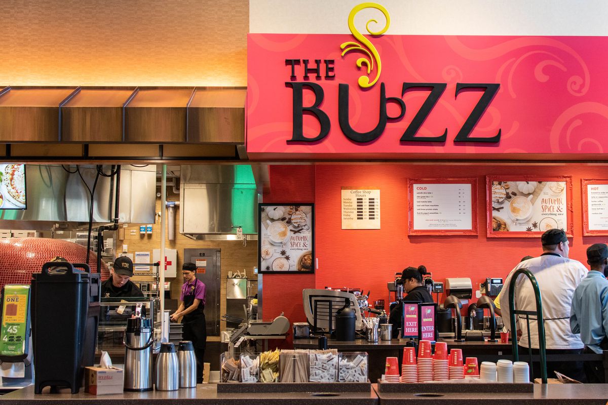 The front of a coffee counter with a red sign reading “THE BUZZ”
