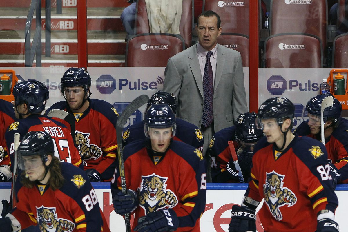 Florida Panthers head coach Kevin Dineen in back of members of the team.