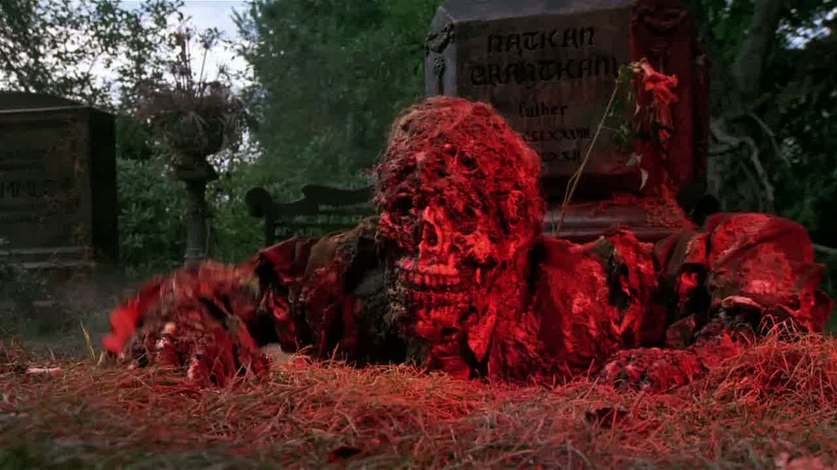 A skeleton bathed in red light looks like it is crawling out of a grave in Creepshow.