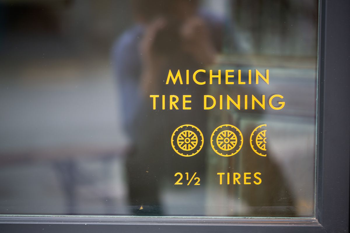 A shot of the front window with decal sign reading “Michelin Tire Dining” and 2 and half tires at Little Bear in Summerhill Atlanta