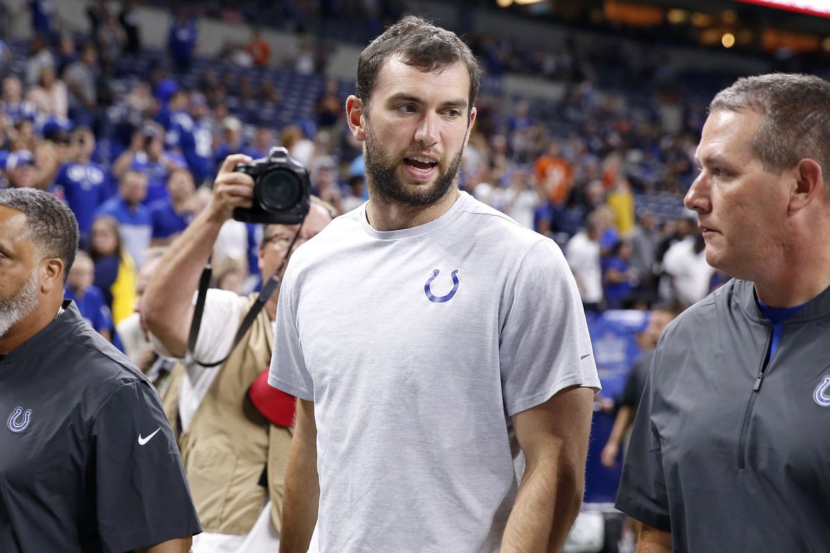 Andrew Luck of the Indianapolis Colts leaves the Field surrounded by photographers and team staff after new of his retirement broke during the game against the Chicago Bears.