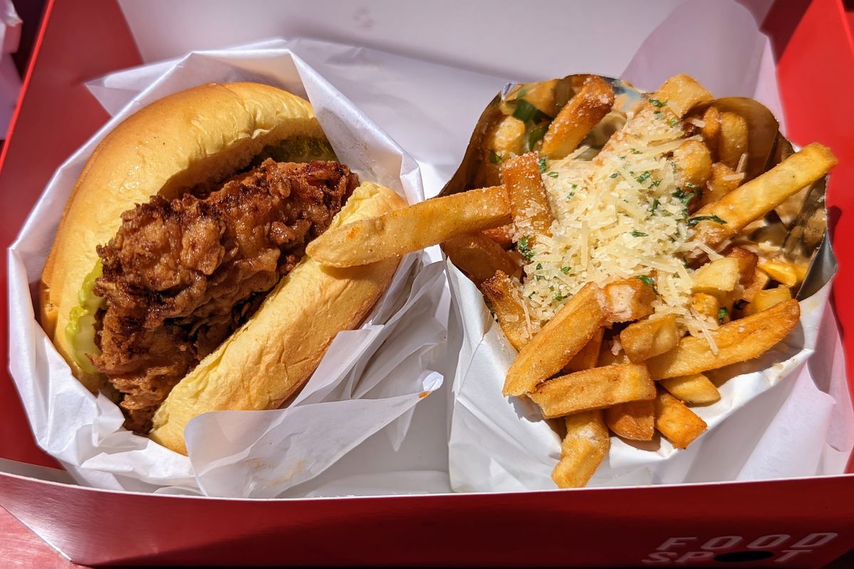 A box with a fried chicken sandwich and garlic cheese fries.