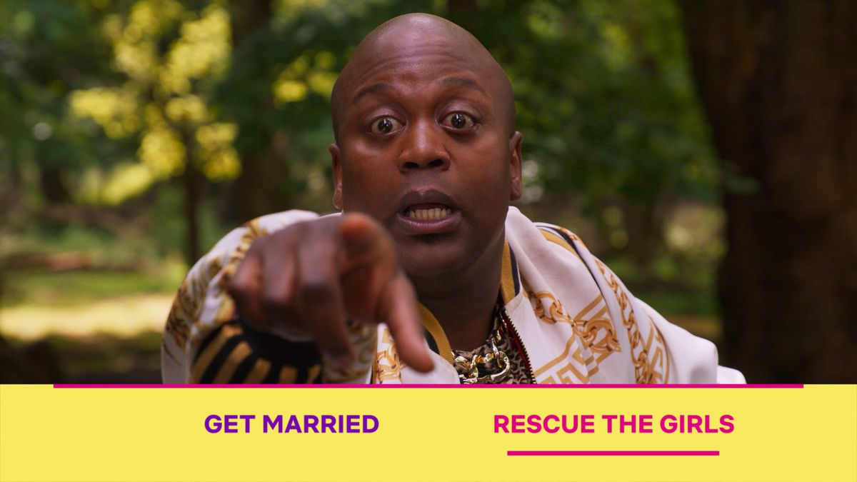 Tituss Burgess points at the screen with his eyes bugged out as Netflix’s Kimmy Schmidt interactive special asks viewers to choose between “Get married” and “Rescue the Girls.”