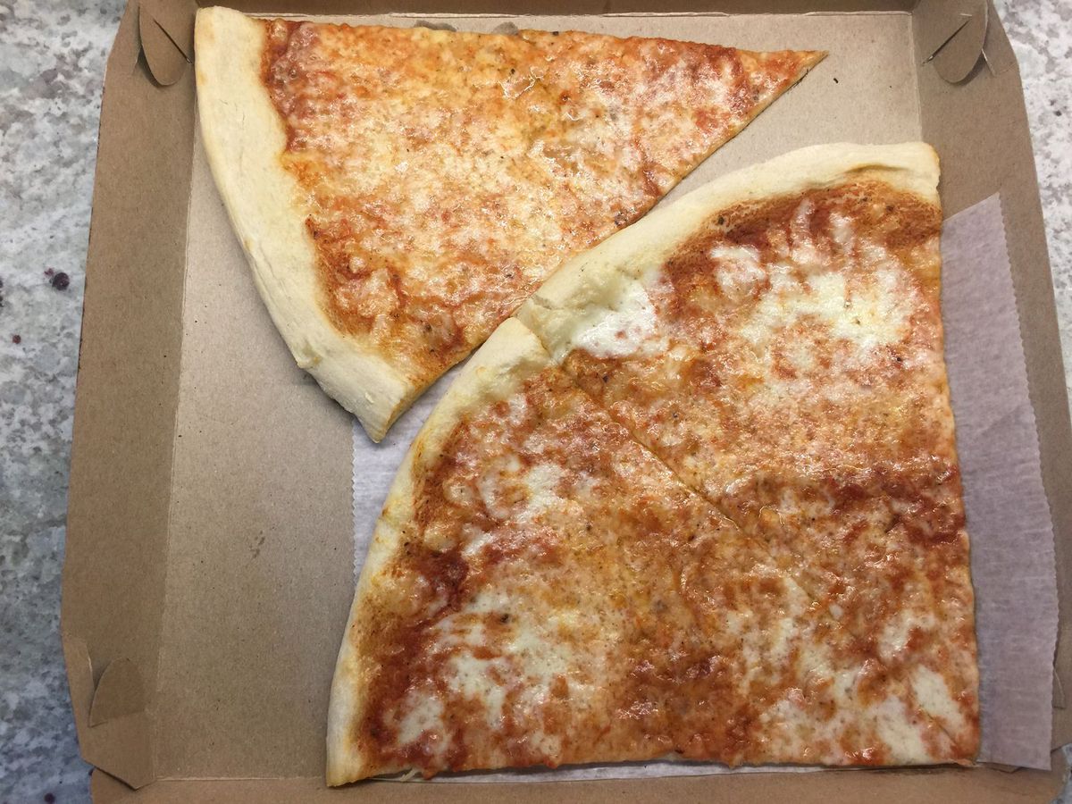Several pizza slices jammed in a box.