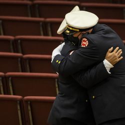 Chicago Fire Department personnel hug and pay their respects before the start of the funeral for firefighter MaShawn Plummer at the House of Hope church on the Far South Side, Thursday morning, Jan. 6, 2022.