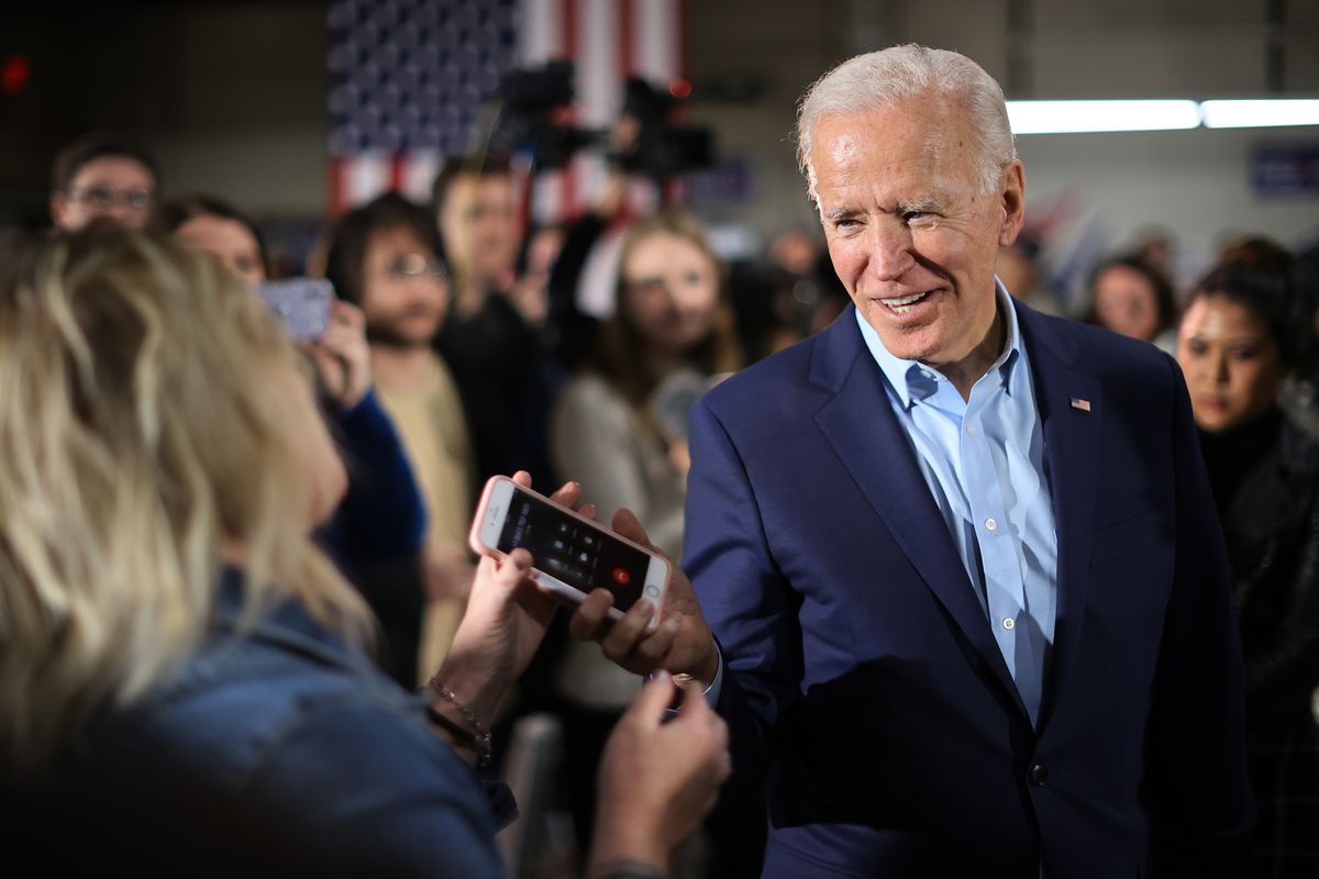 Democratic presidential candidate Joe Biden returns a supporter’s phone after talking to her relative during a campaign event at the Central Iowa Fairgrounds on January 26, 2020, in Marshalltown, Iowa.