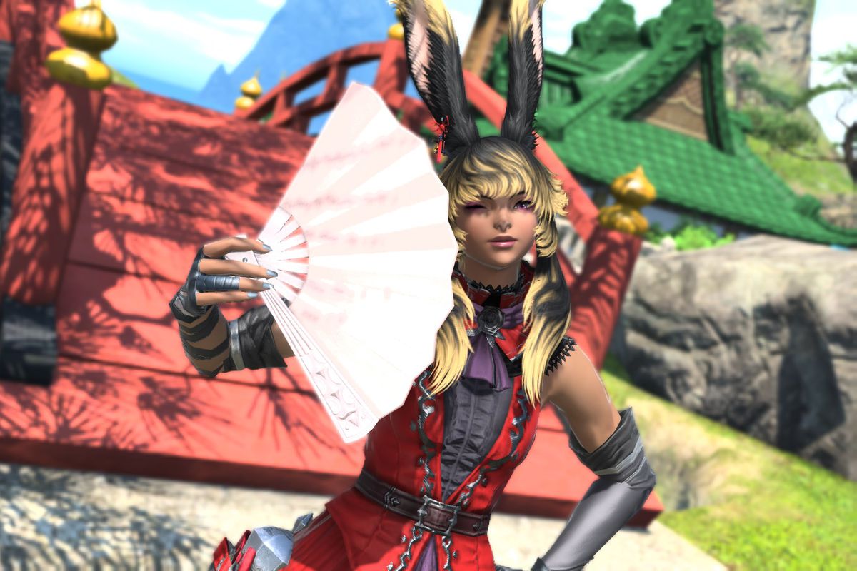 A Viera dressed in red winks while holding a light pink fan in Final Fantasy 14