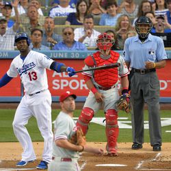 Los Angeles Dodgers' Hanley Ramirez, left, hits a three-run home run as Philadelphia Phillies starting pitcher Cliff Lee, second from left, looks on along with catcher Carlos Ruiz, second from right, and home plate umpire CB Bucknor during the first inning of their baseball game, Saturday, June 29, 2013, in Los Angeles. 