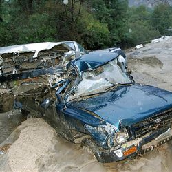 Two cars sit damaged by flood waters and mud on Ocean View Boulevard in La Canada Flintridge, Calif., Saturday.