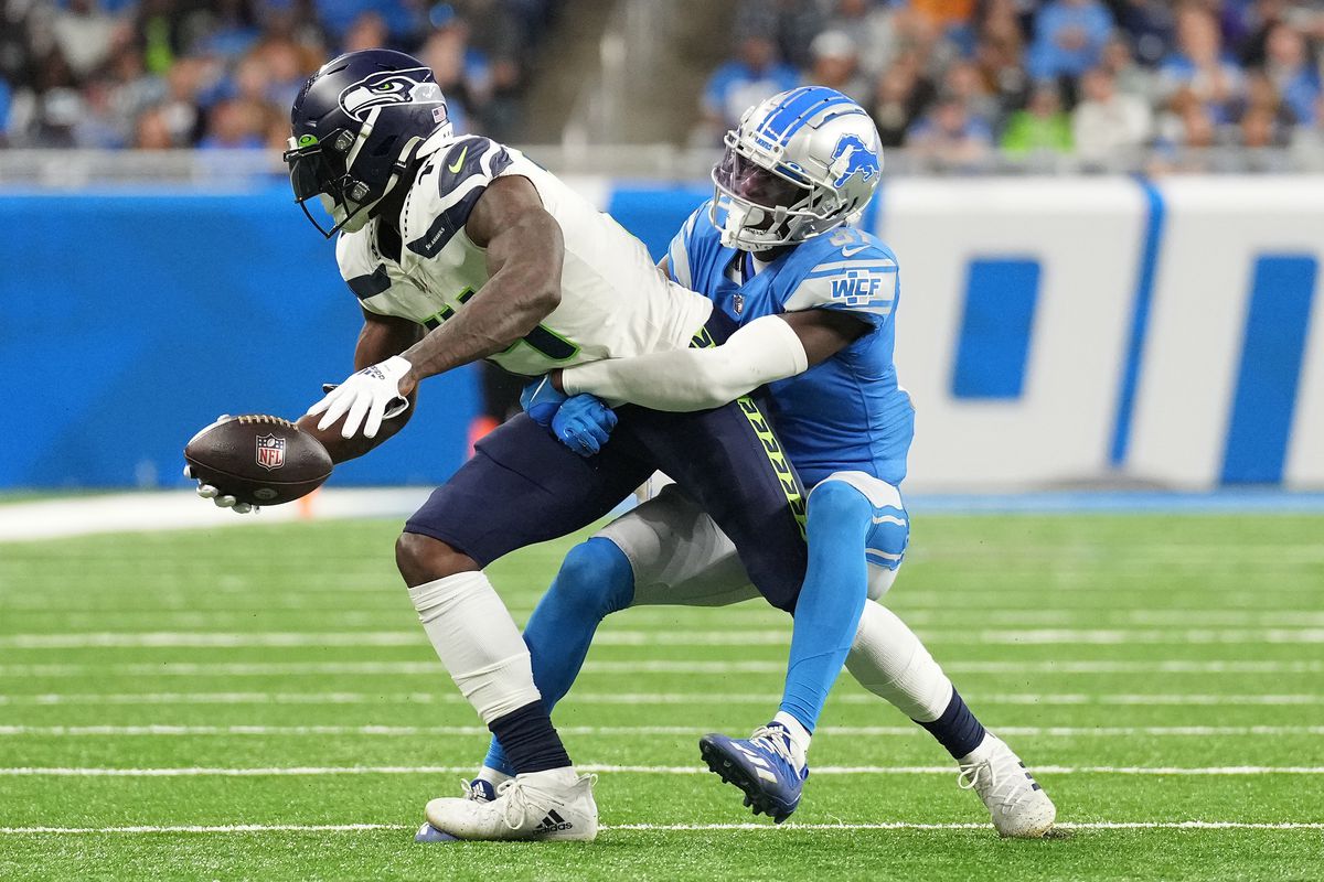 Kerby Joseph #31 of the Detroit Lions tackles DK Metcalf #14 of the Seattle Seahawks during the second half of the game at Ford Field on October 02, 2022 in Detroit, Michigan.