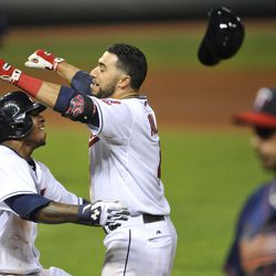  Minnesota Twins first baseman Chris Colabello (right) walks off the field as Cleveland Indians second baseman Mike Aviles (4) celebrates his game-winning single with   center fielder Nyjer Morgan (left) in the ninth inning at Progressive Field.